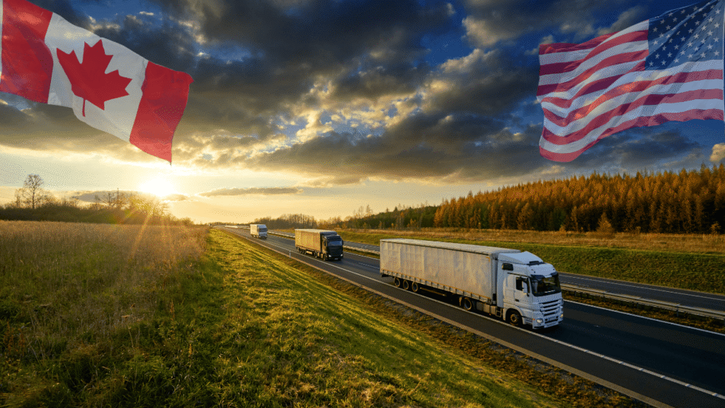 Canada vs US fuel card networks concept showing semi trucks driving on a highway at sunset with the Canadian flag on one side and the United States flag on the other, representing cross-border trucking and fuel card network differences.